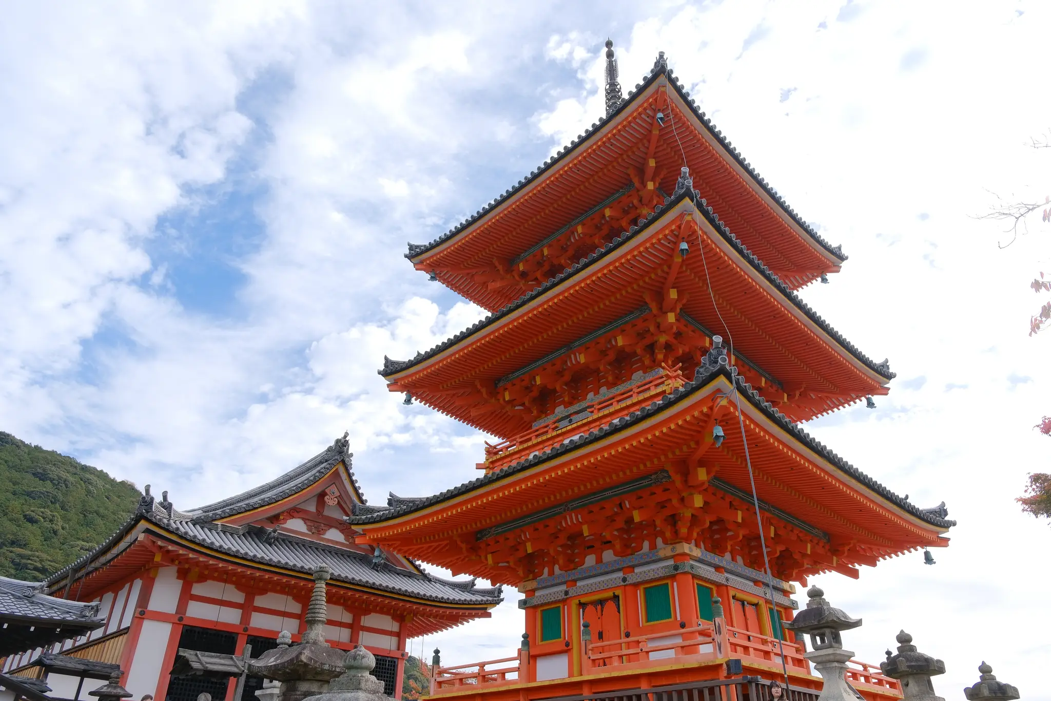 The vermilion three-storey pagoda at Kiyomizu-dera against a bright sky