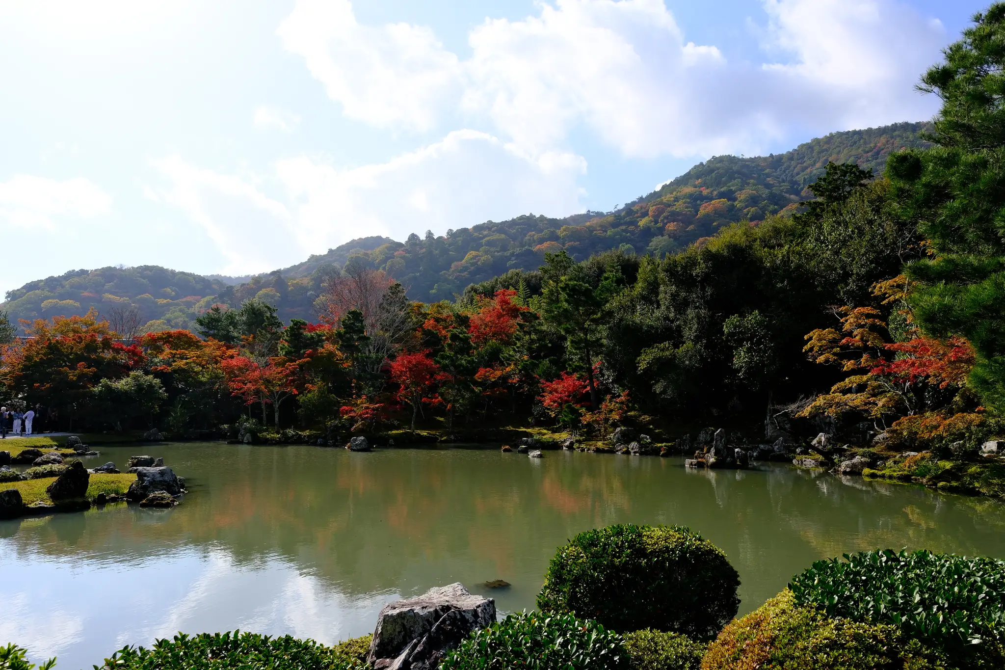 The Tenryu-ji pond garden with autumn colours and mountains behind